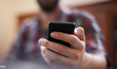 휴대 전화를 들고 있는 손